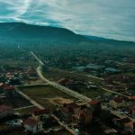 an aerial view of a town with mountains in the background
